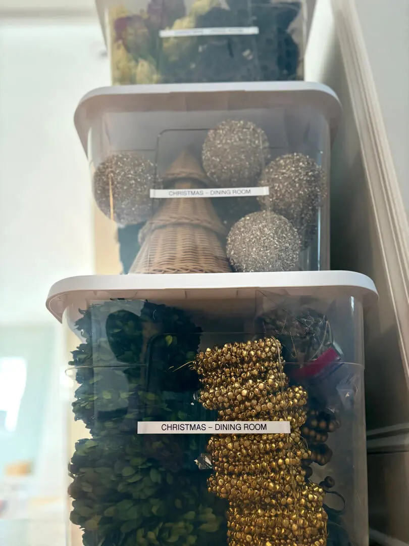 Totes of decorations labeled by room, including Christmas dining room