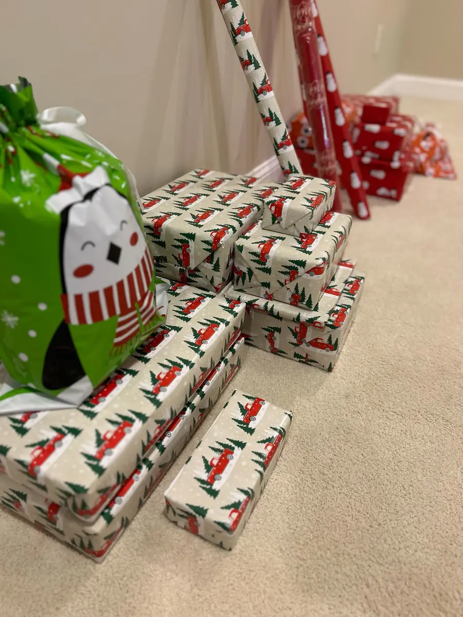 A pile of wrapped presents with a penguin gift bag