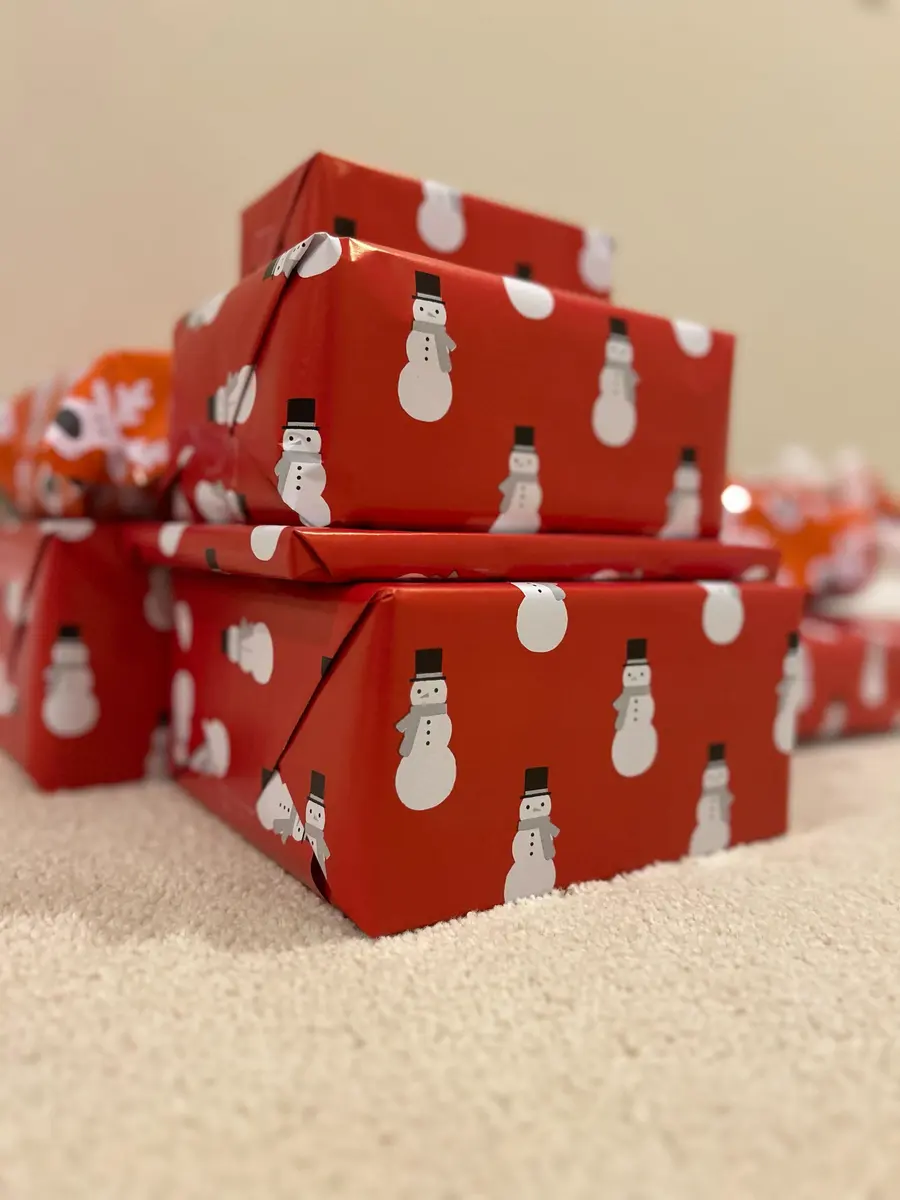 A stack of presents wrapped in red snowman paper