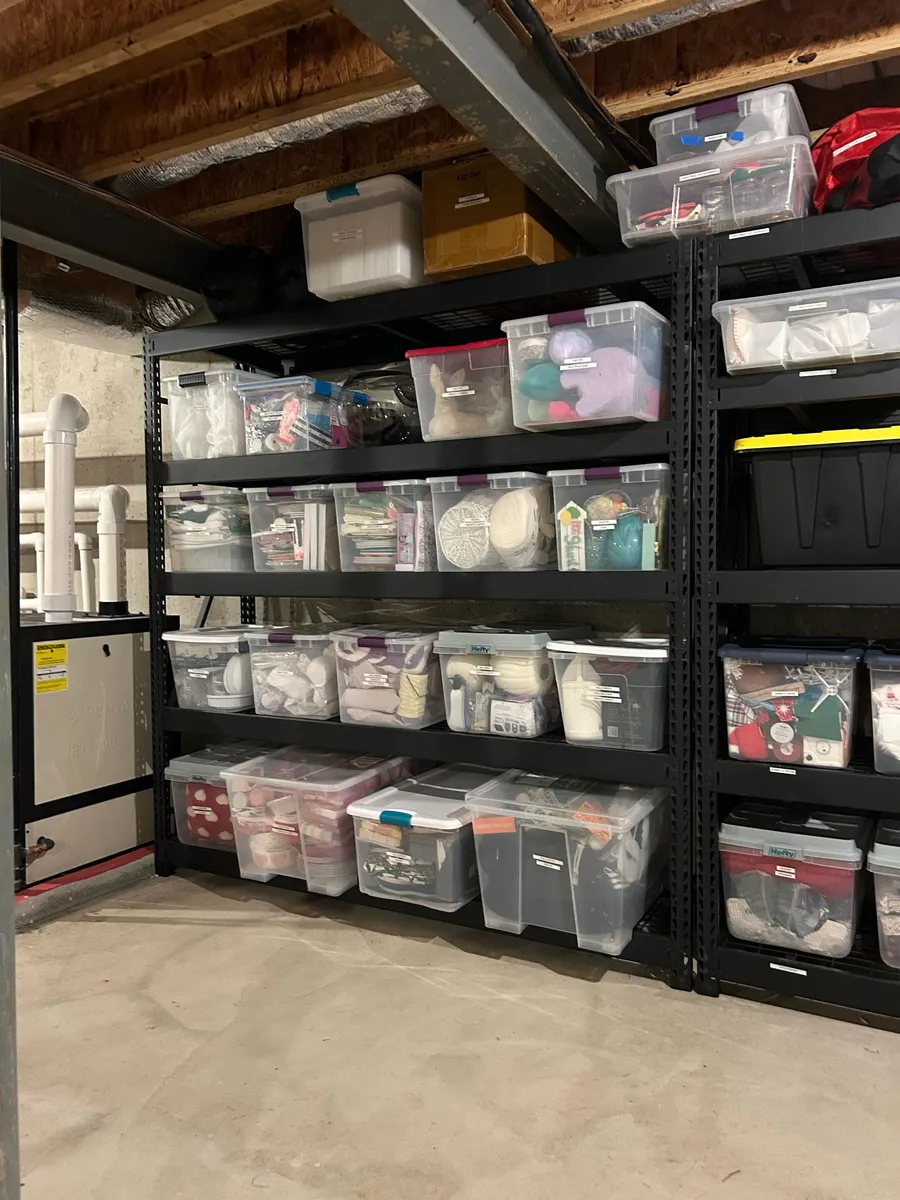 Labeled clear totes lined up on basement shelving