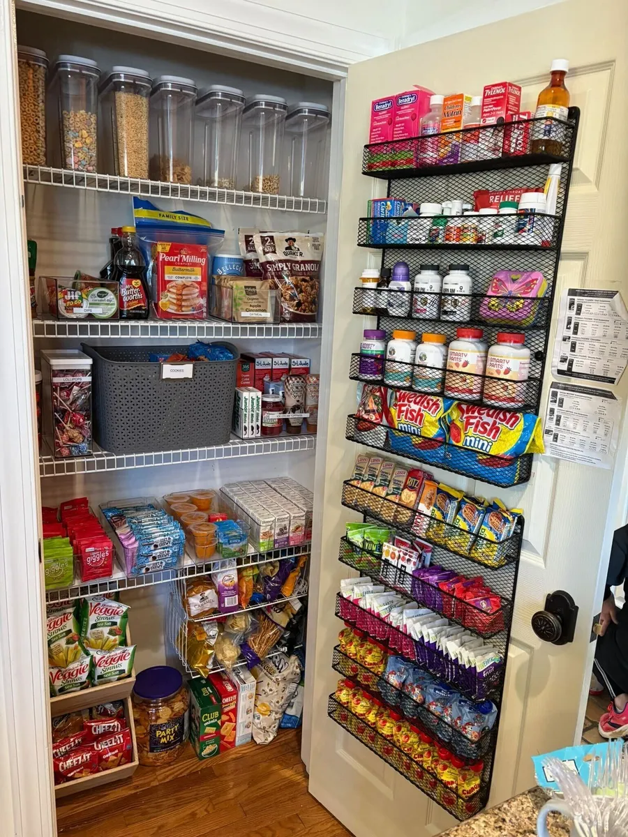 A pantry of cereal canisters and a door rack of snacks and medicine