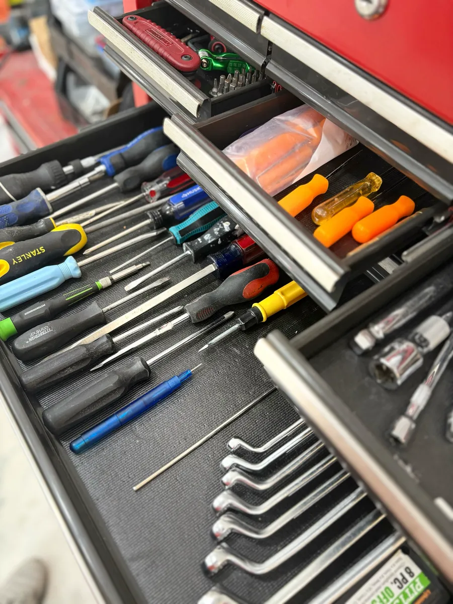 Screwdrivers and wrenches laid out in toolbox drawers