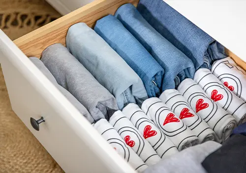 Jeans and shirts organized in a drawer and neatly folded